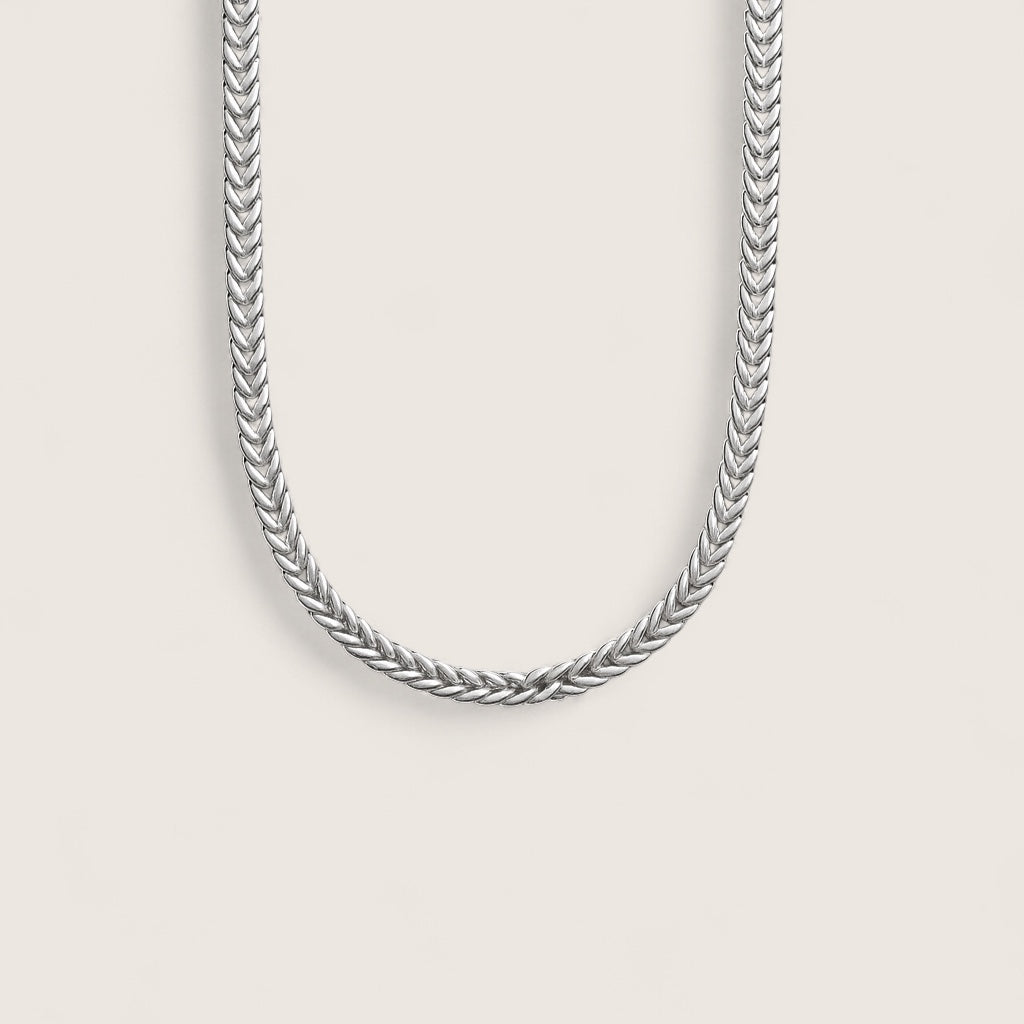 Silver chain necklace on a light gray background