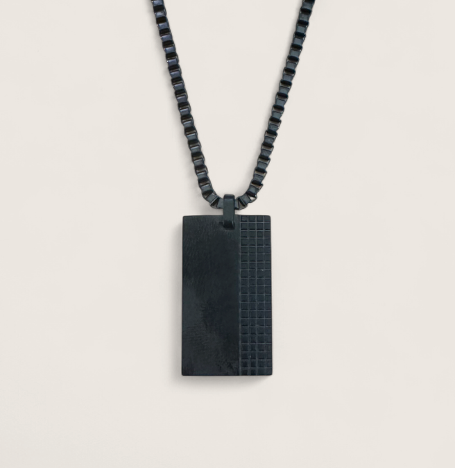 The Obsidian Grid – 40 mm Oxidized Dog Tag Necklace-Strike bold balance with the Obsidian Grid Tag. Black steel dog tag with brushed and grid-textured finish on a chain. Industrial edge meets style. Shop now.