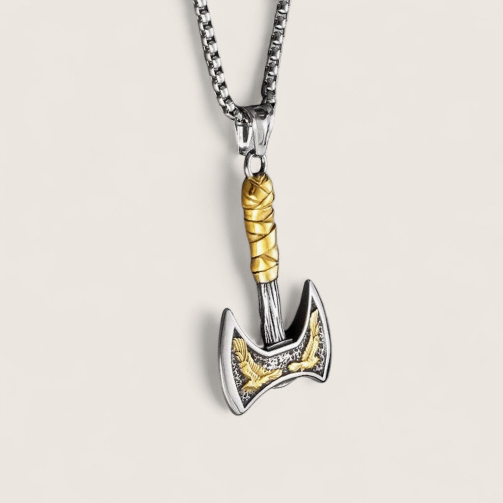 Metallic axe-shaped pendant on a chain against a light background