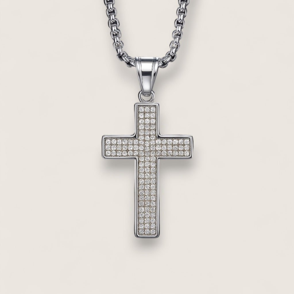 Silver cross pendant necklace on a light gray background