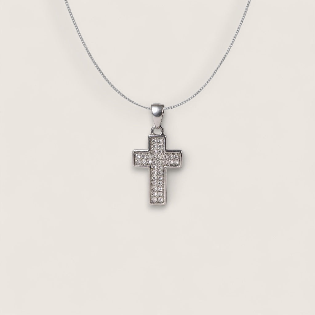 Silver cross pendant necklace on a light gray background