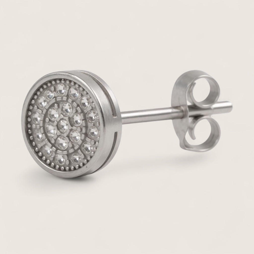 Silver stud earring with clear gemstones on a light gray background