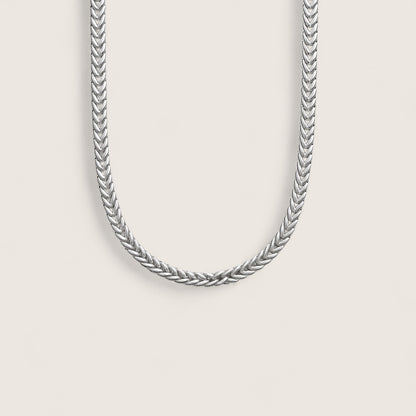 Silver chain necklace on a light gray background
