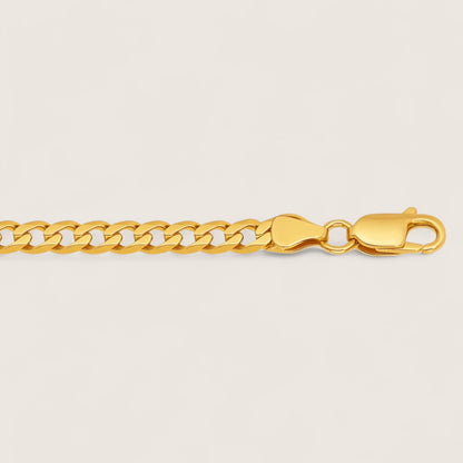 Gold chain bracelet on a light beige background