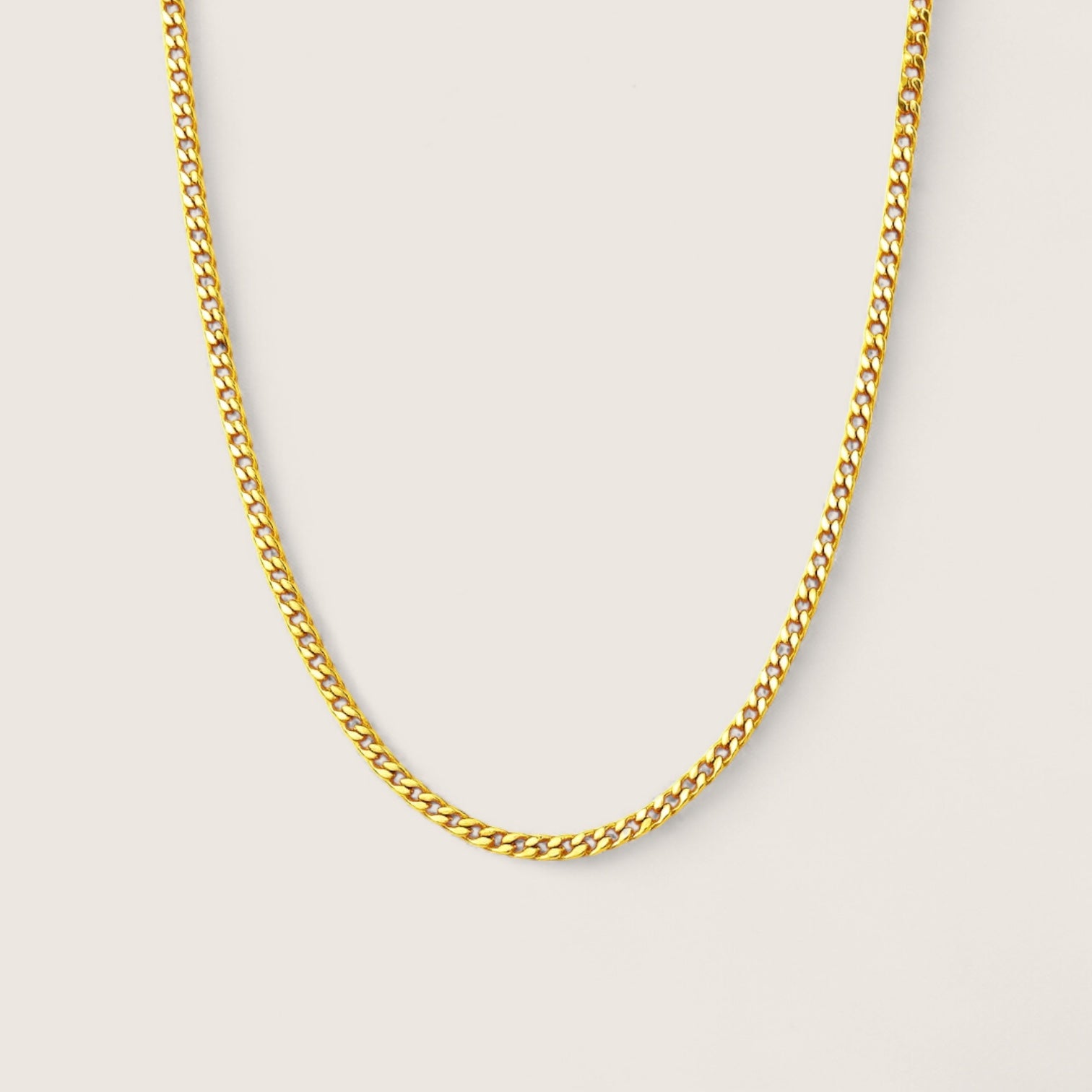 Gold chain necklace on a light gray background