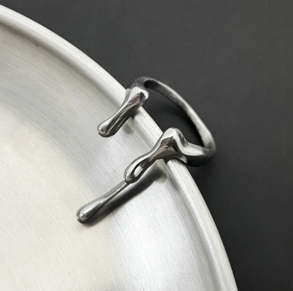 Reactor Drip – Statement Ring-Channel raw energy with the Reactor Drip Ring. Polished steel, sculptural open-band design with opposing arcs. Adjustable fit. Shop now.