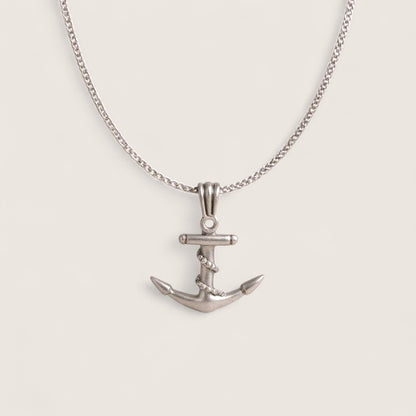 Silver anchor necklace on a light gray background