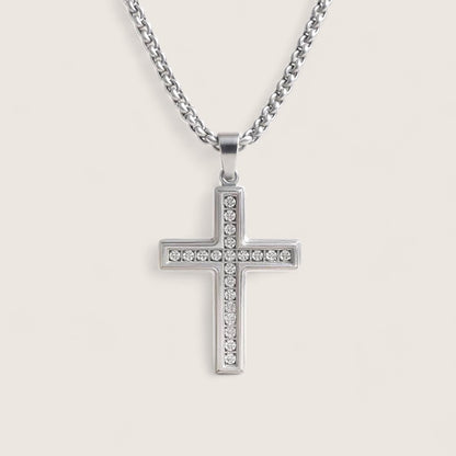 Silver cross pendant necklace on a light gray background