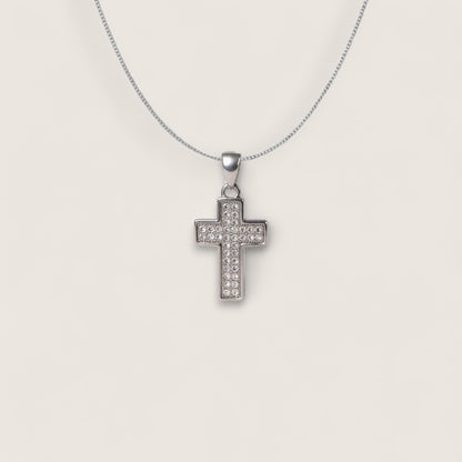 Silver cross pendant necklace on a light gray background