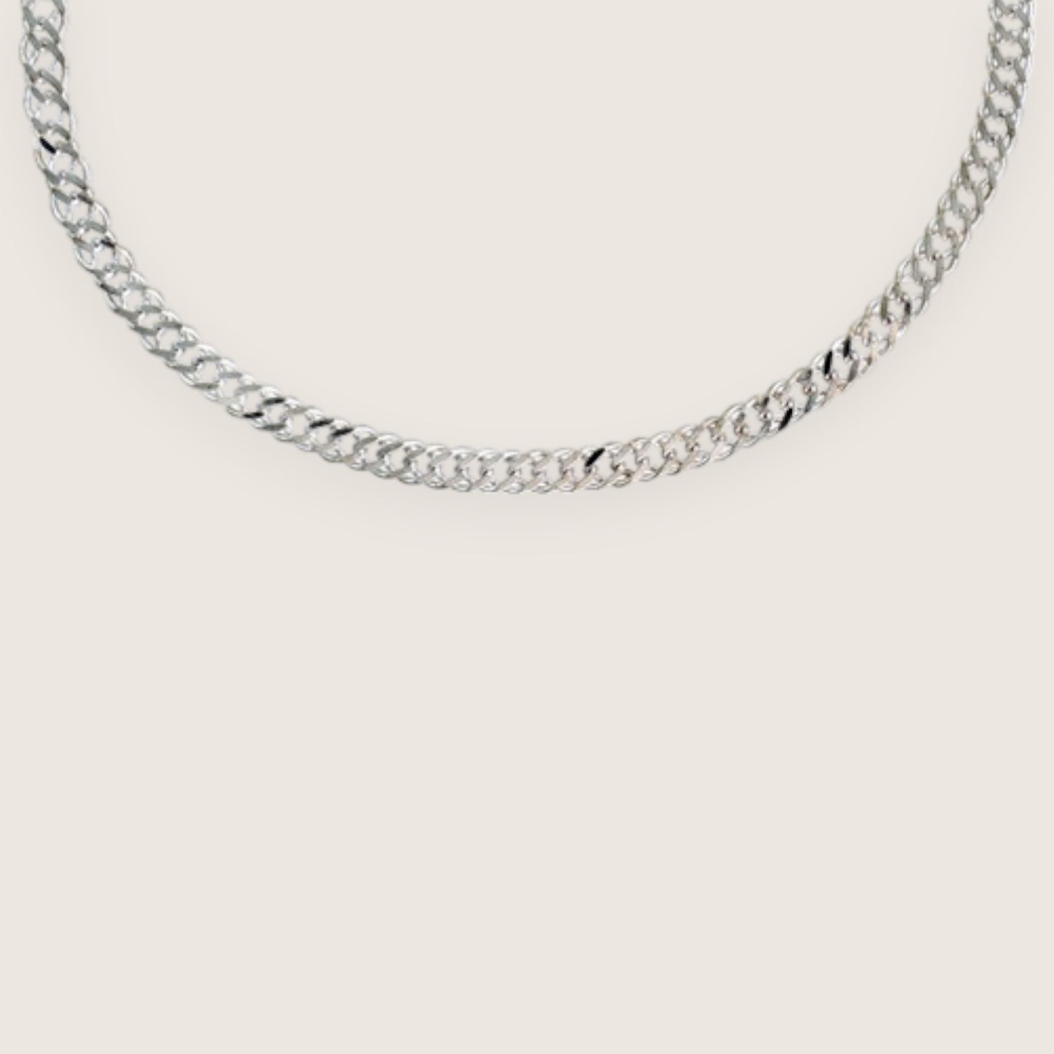 Silver chain necklace on a light gray background