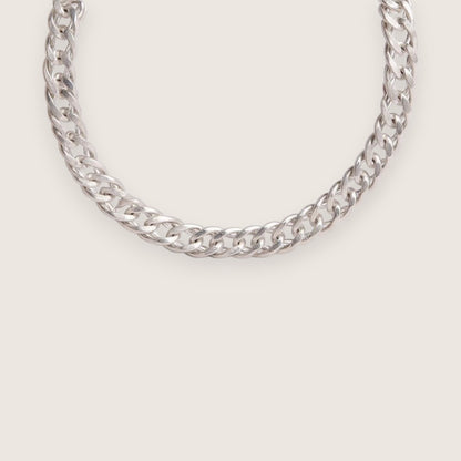 Silver chain necklace on a light gray background