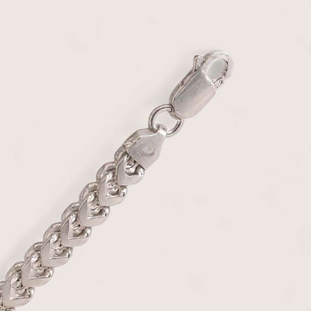Silver chain bracelet with a clasp on a light gray background