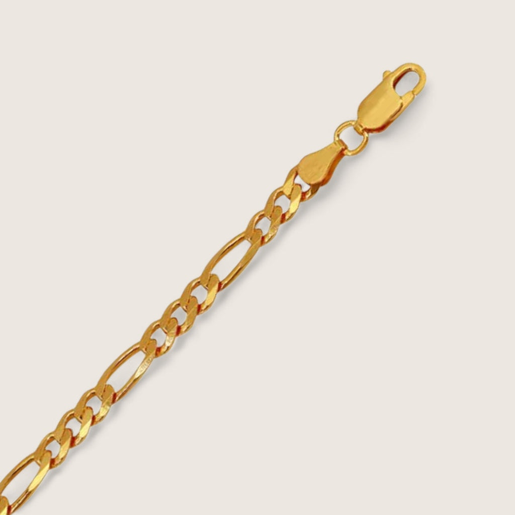 Gold chain bracelet on a beige background