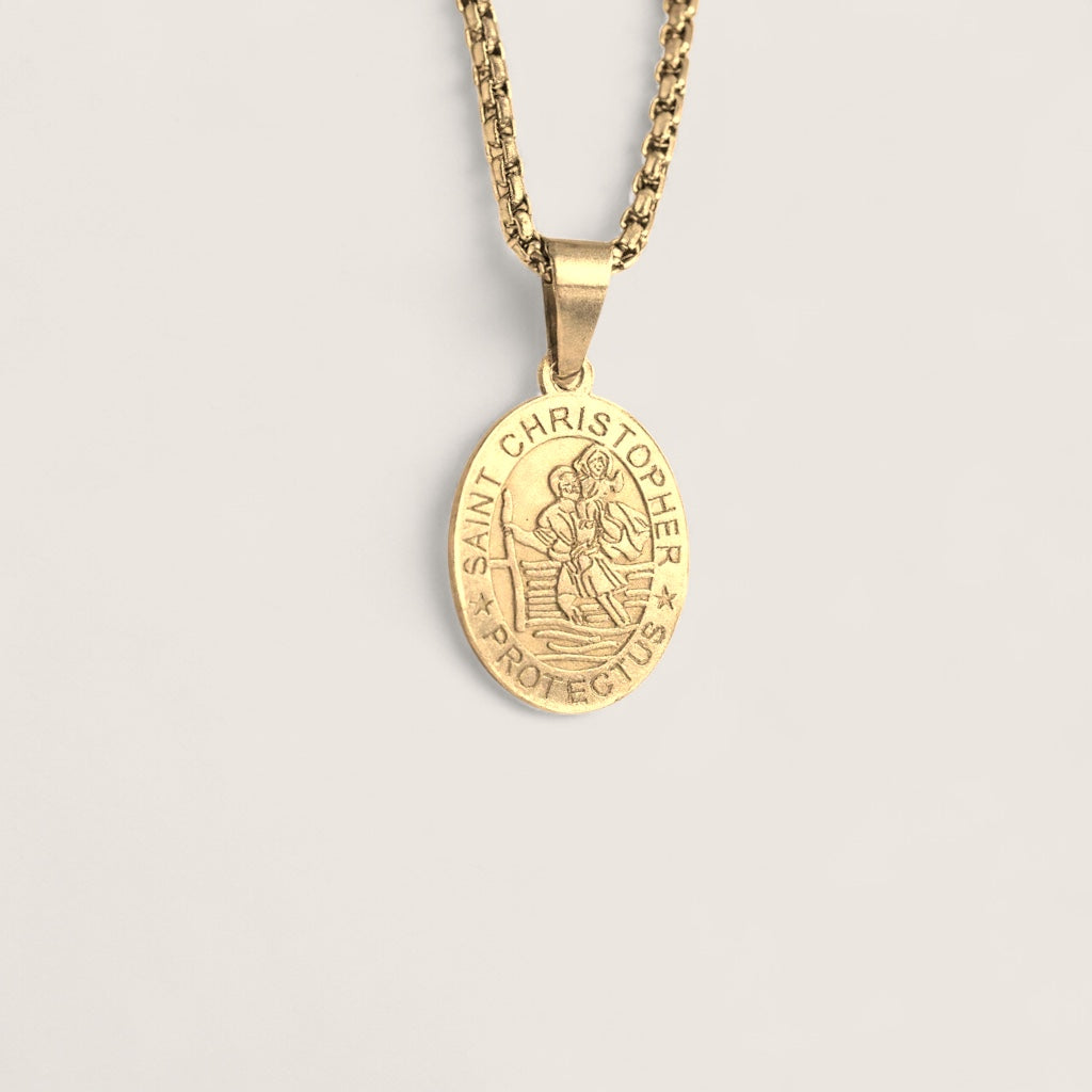 Gold Saint Christopher pendant on a chain against a light background